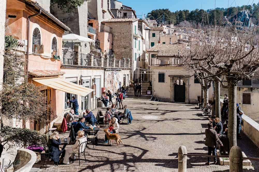 personnes assises sur des chaises près d’un bâtiment en béton brun pendant la journée