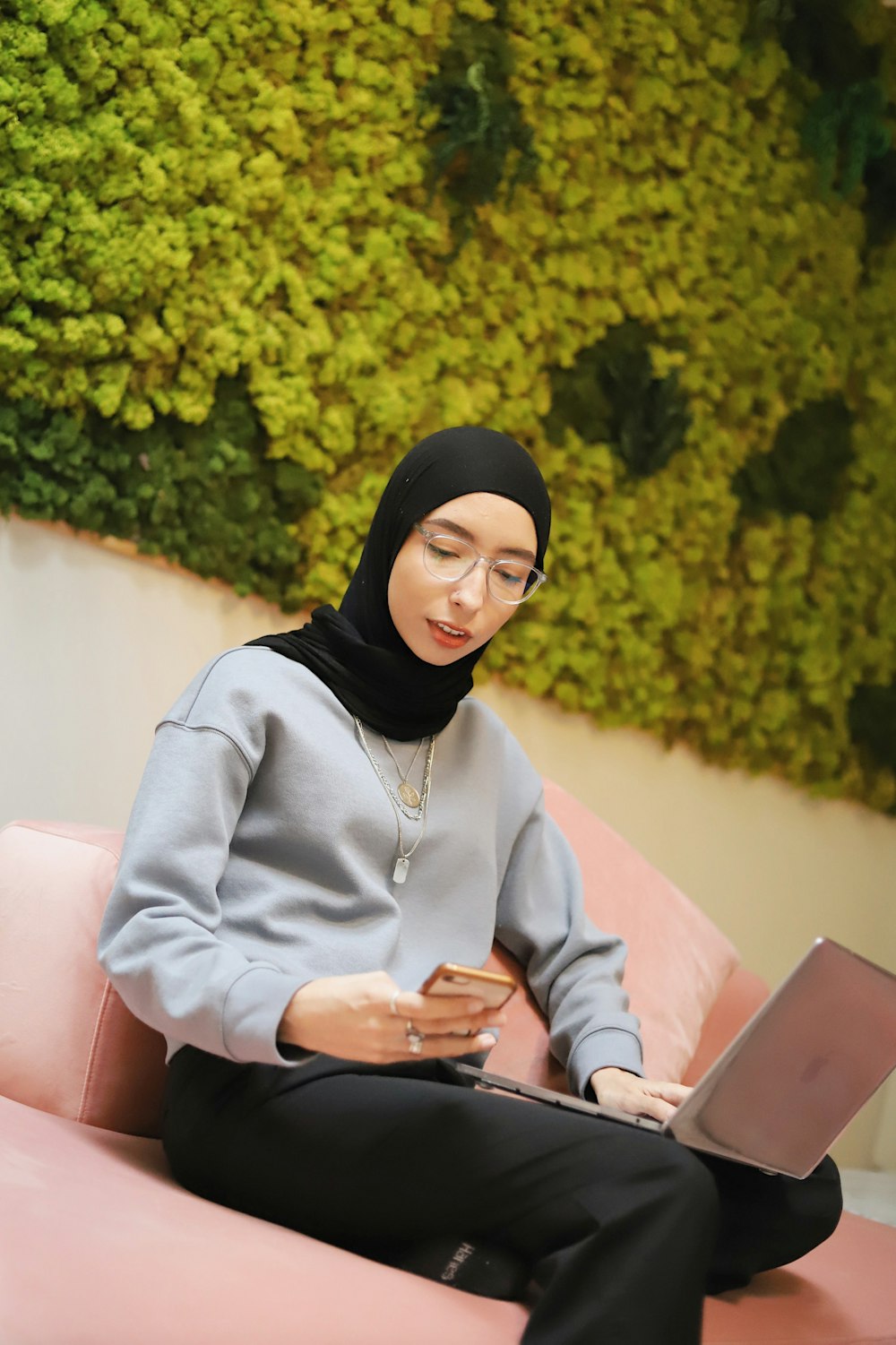 woman in black hijab using silver ipad