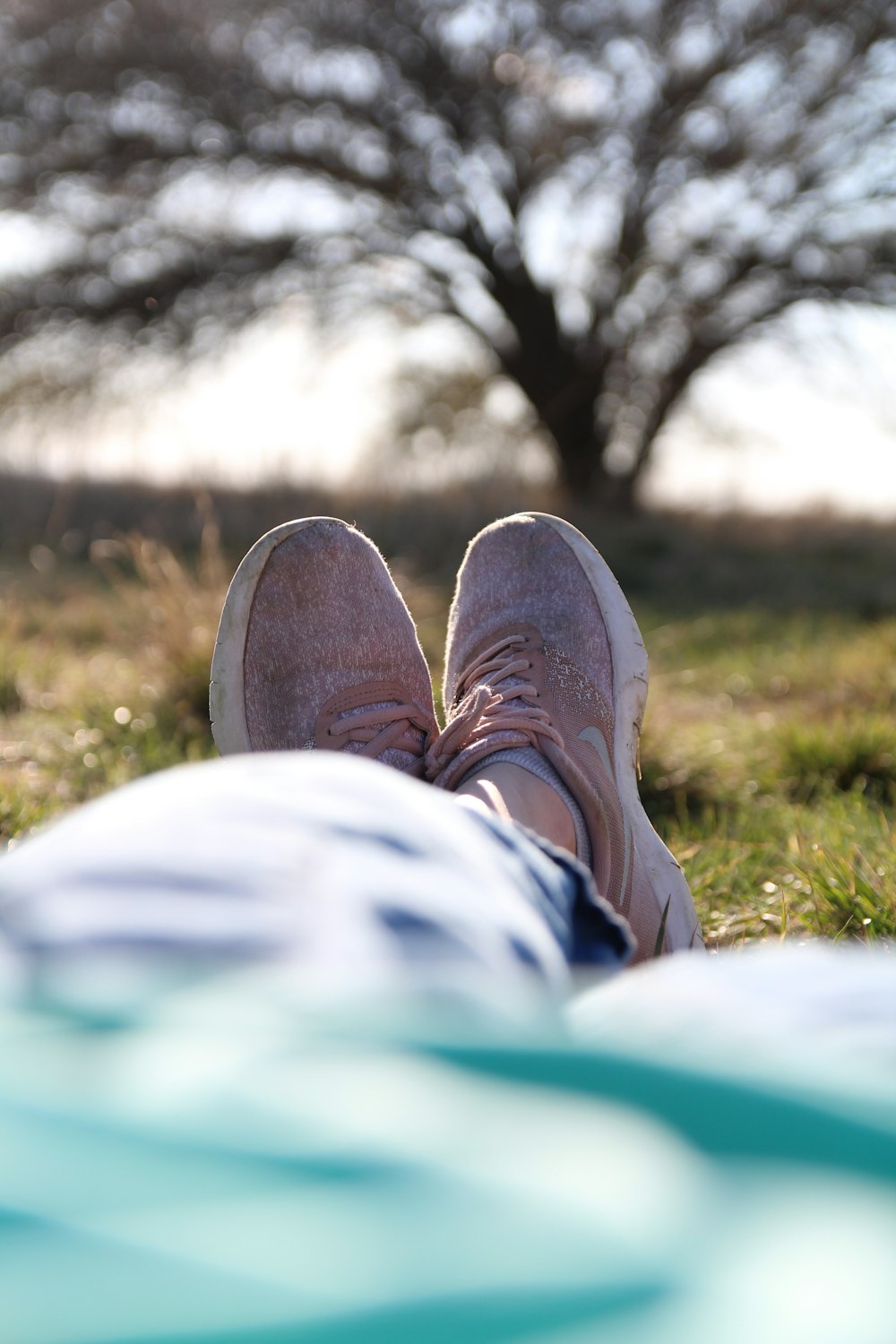 person in brown shoes sitting on green grass field during daytime