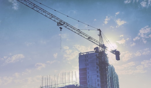 A crane lifting materials at a large construction site during daylight.