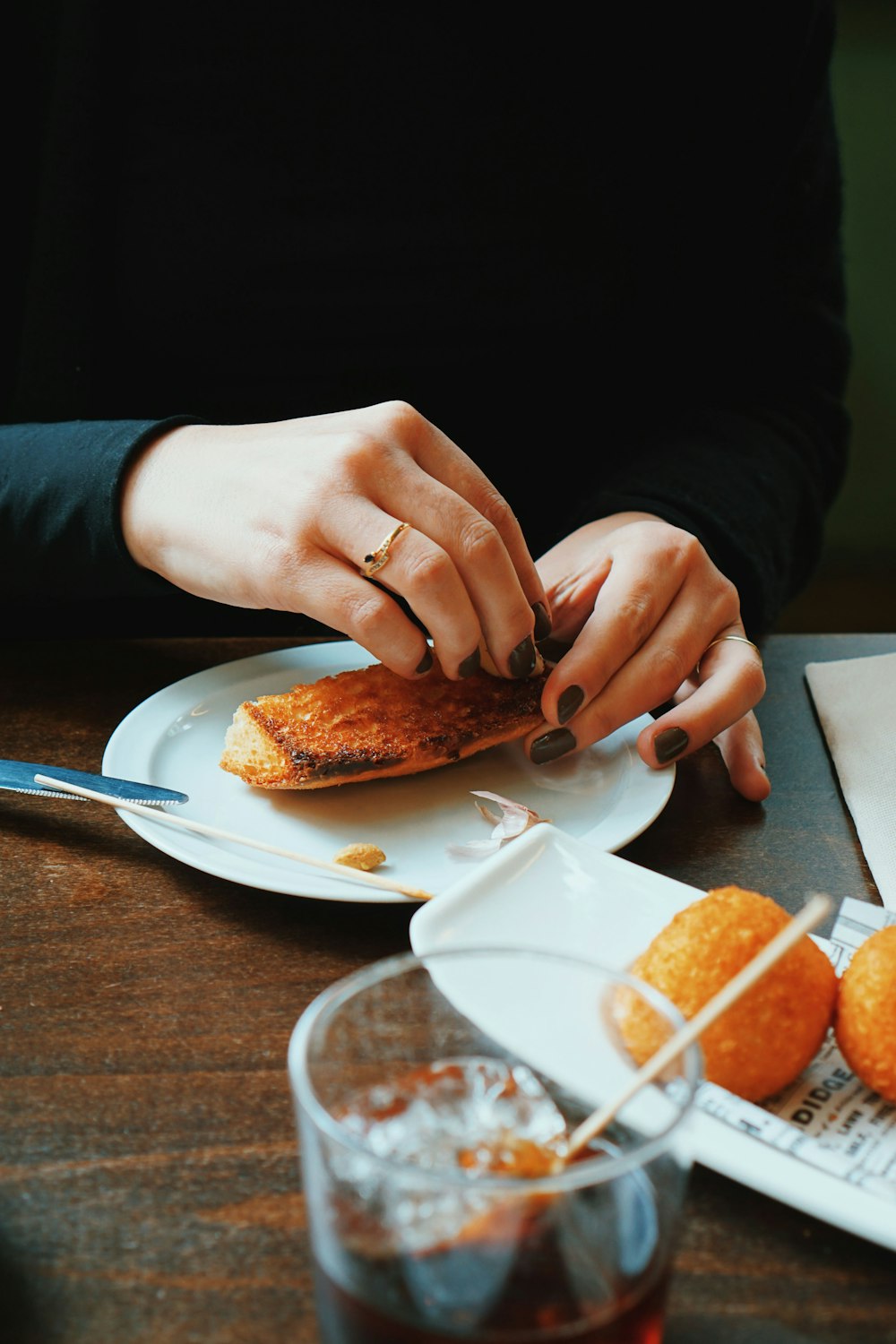 person holding sliced of bread on white ceramic plate