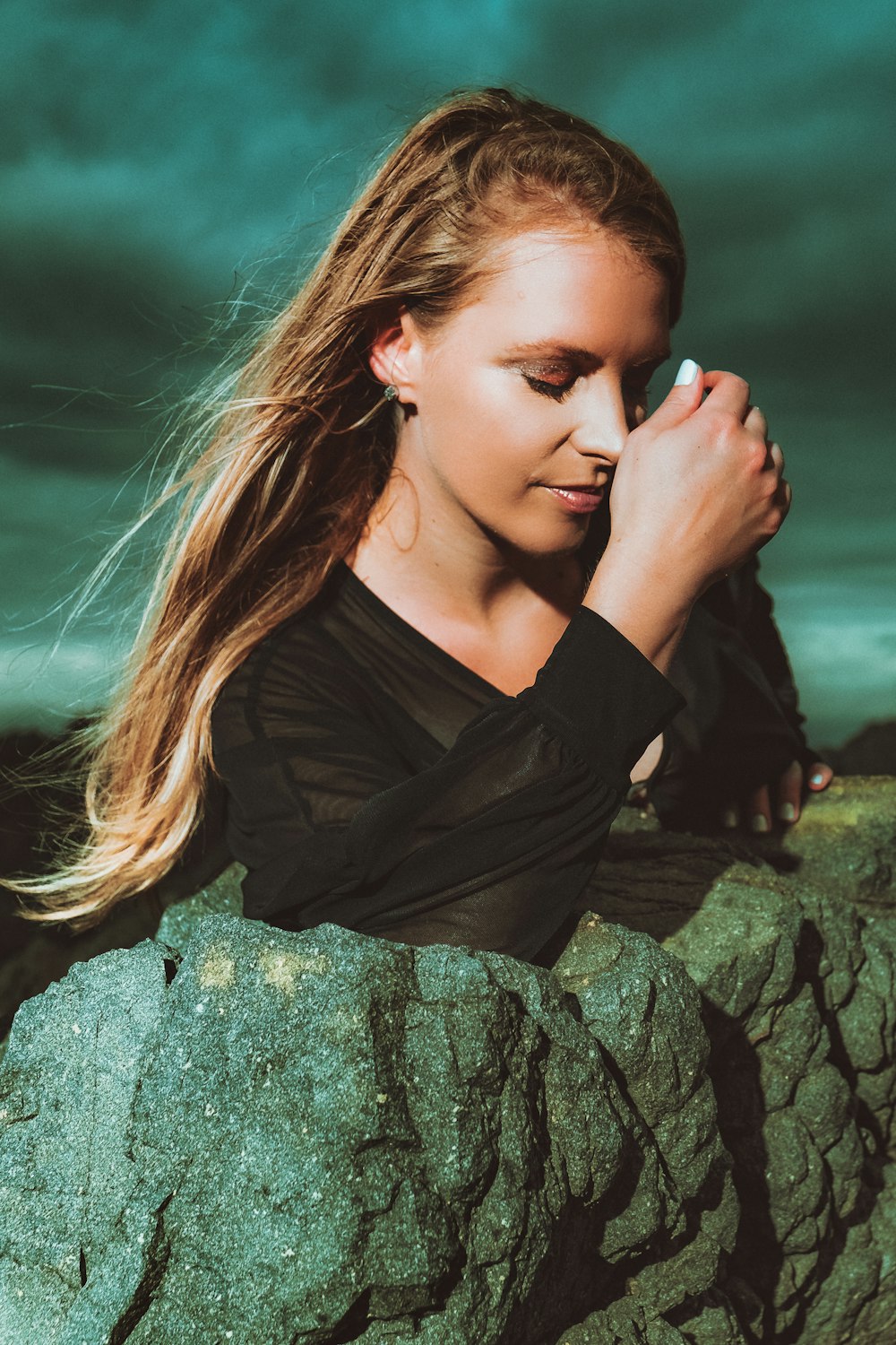 woman in black long sleeve shirt sitting on rock