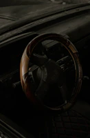 Close-up of a car's steering wheel and dashboard with a focus on details.