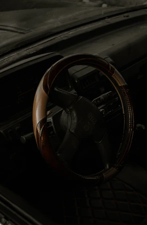 Close-up of a car's steering wheel and dashboard with a focus on details.