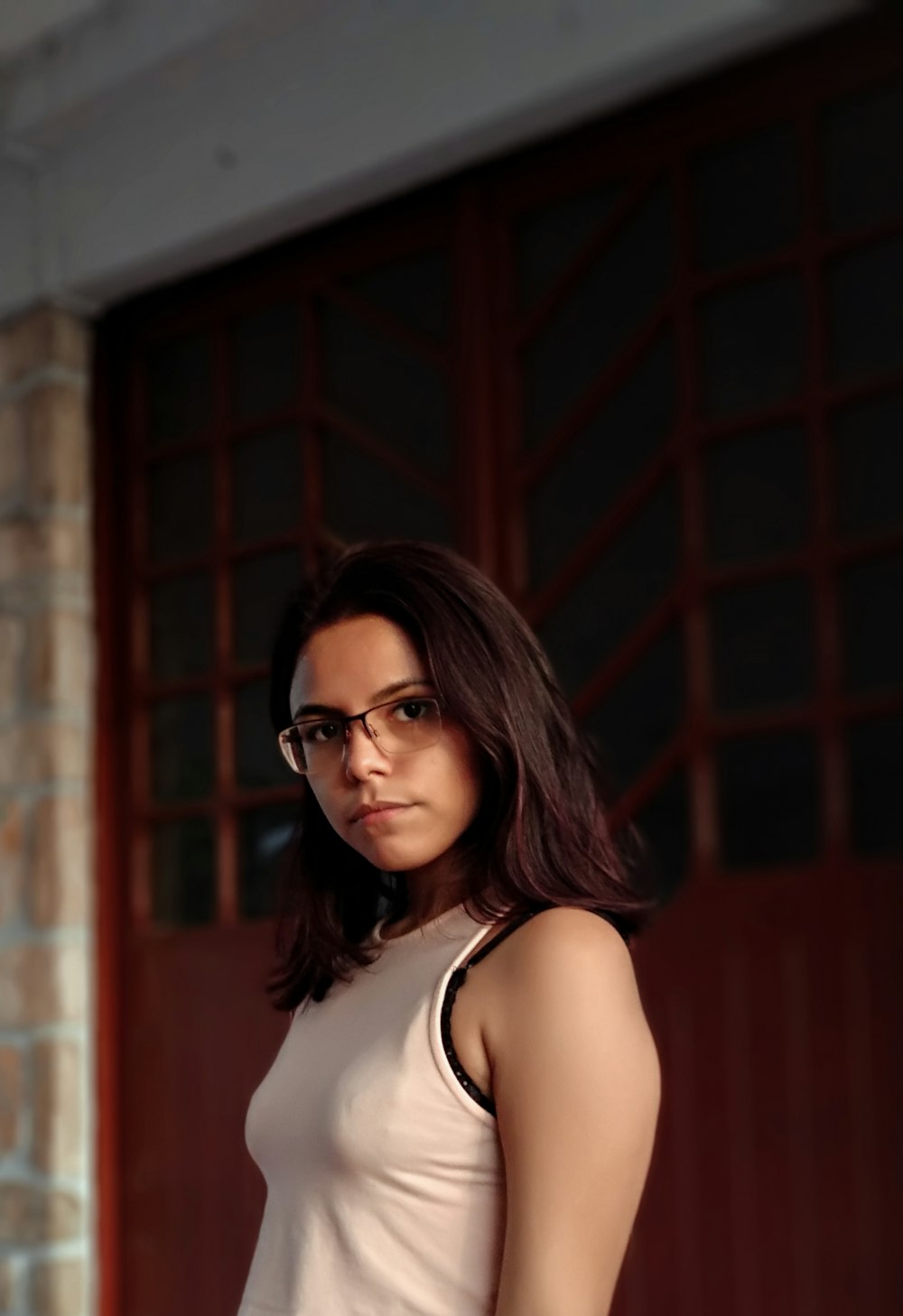 woman in white tank top wearing black framed eyeglasses