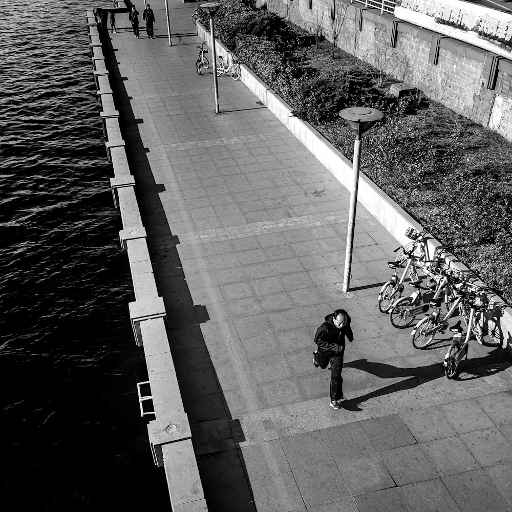 person in black jacket riding bicycle on gray concrete bridge during daytime