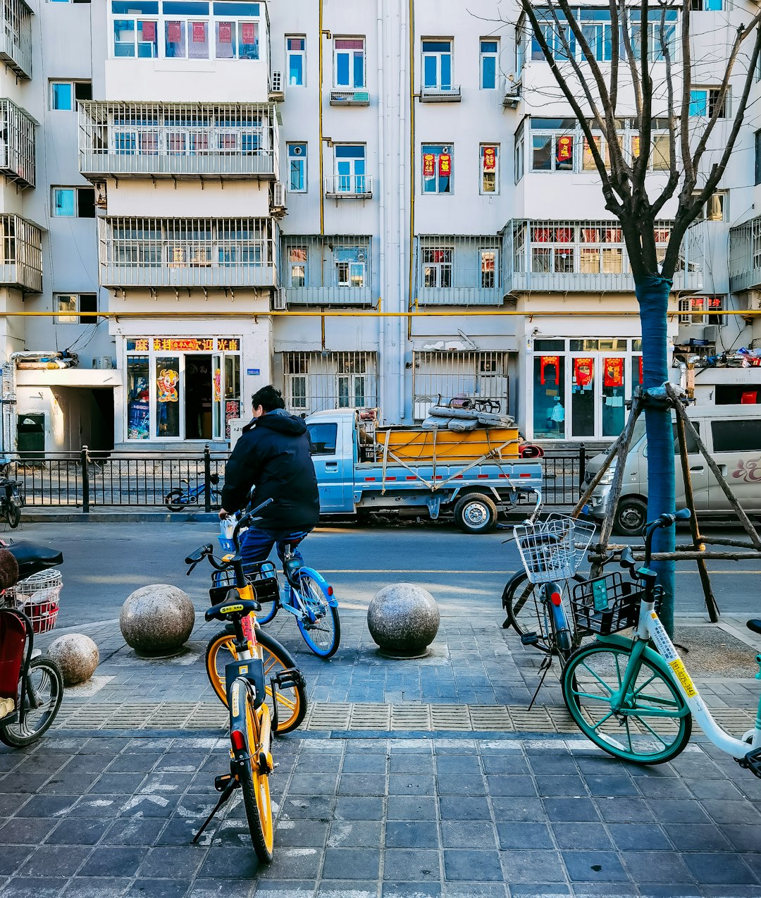 man in black jacket riding bicycle on sidewalk during daytime