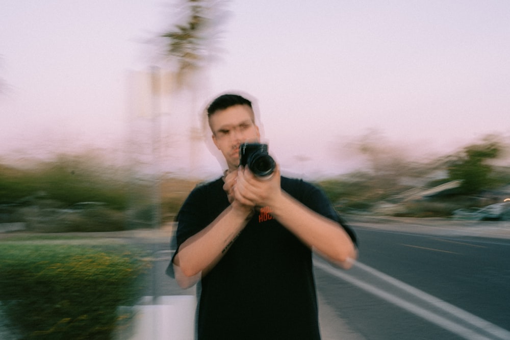 man in black tank top holding black camera