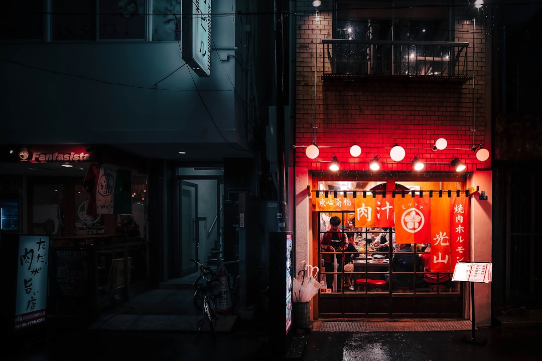 red and yellow neon signage, Spending time at a restaurant on a rainy day in Tokyo