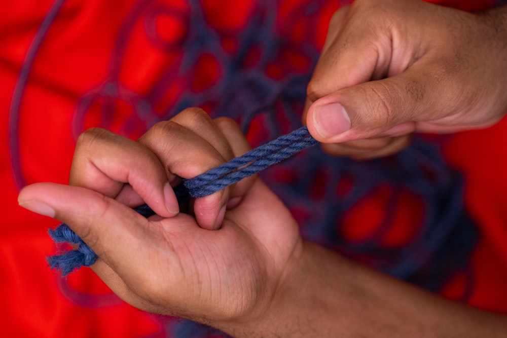 personne tenant une corde bleue et blanche