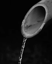 Close-up of a plumber clearing a clogged drain pipe using specialized equipment.