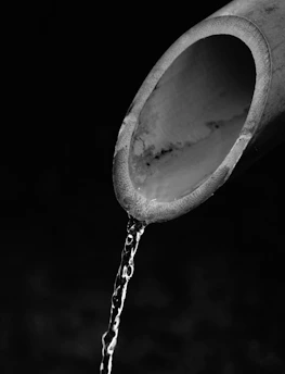 Close-up of a plumber clearing a clogged drain pipe using specialized equipment.
