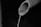 A close-up view of a partially visible pipe with water flowing out of its open end, set against a dark, indistinct background.