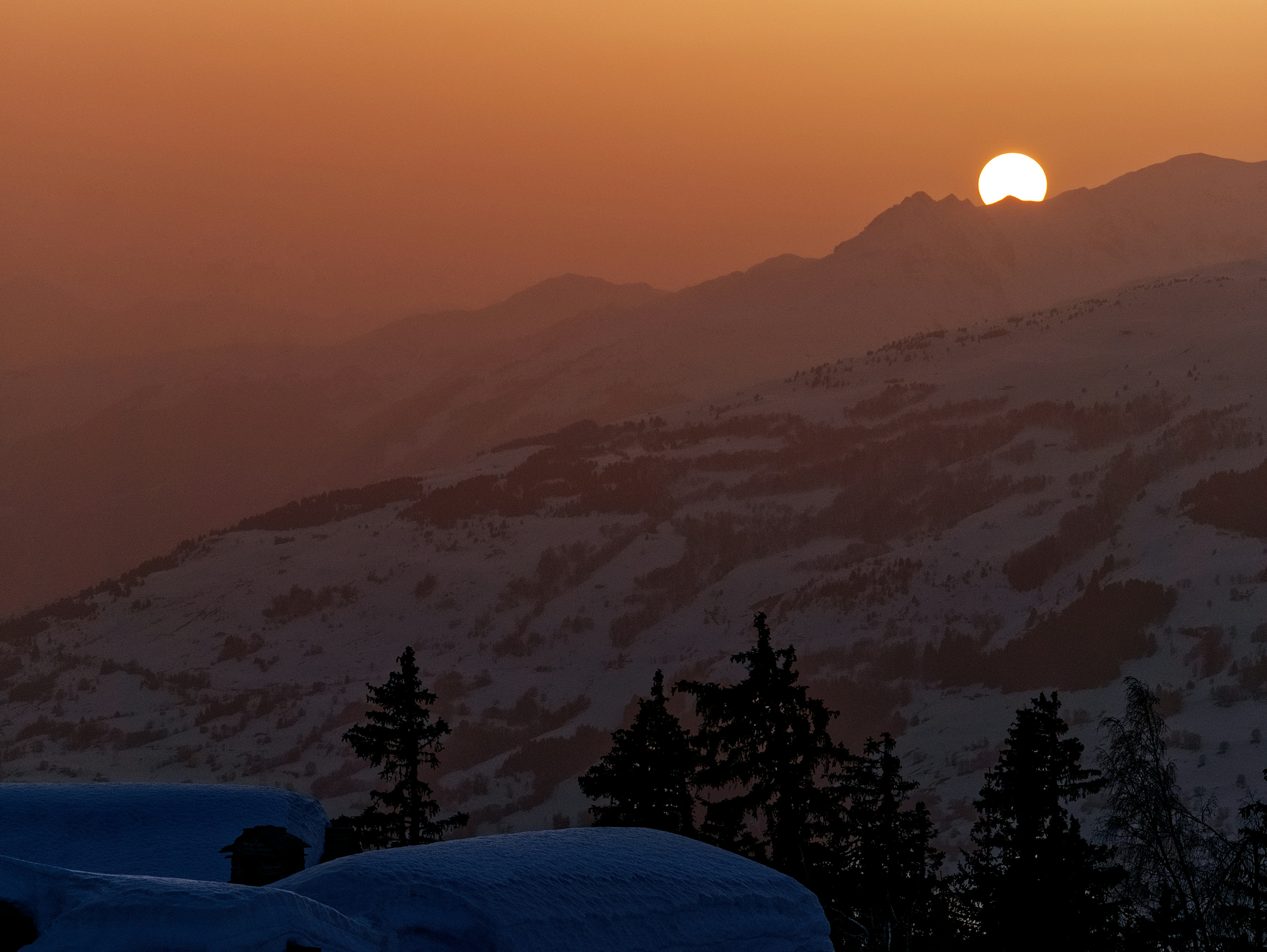 silhouette of trees and mountains during sunset