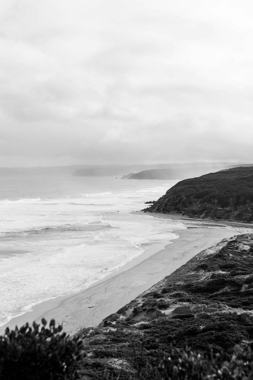 grayscale photo of ocean waves crashing on shore