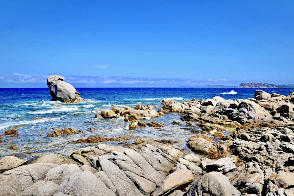 brown rocks on blue sea under blue sky during daytime