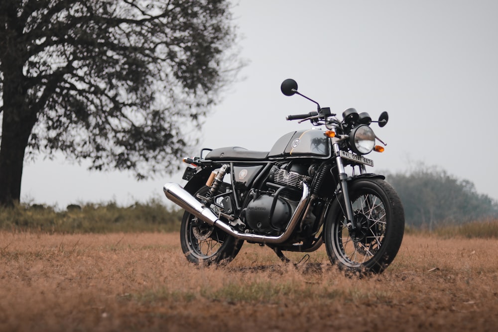 motocicleta negra en el campo de hierba marrón durante el día