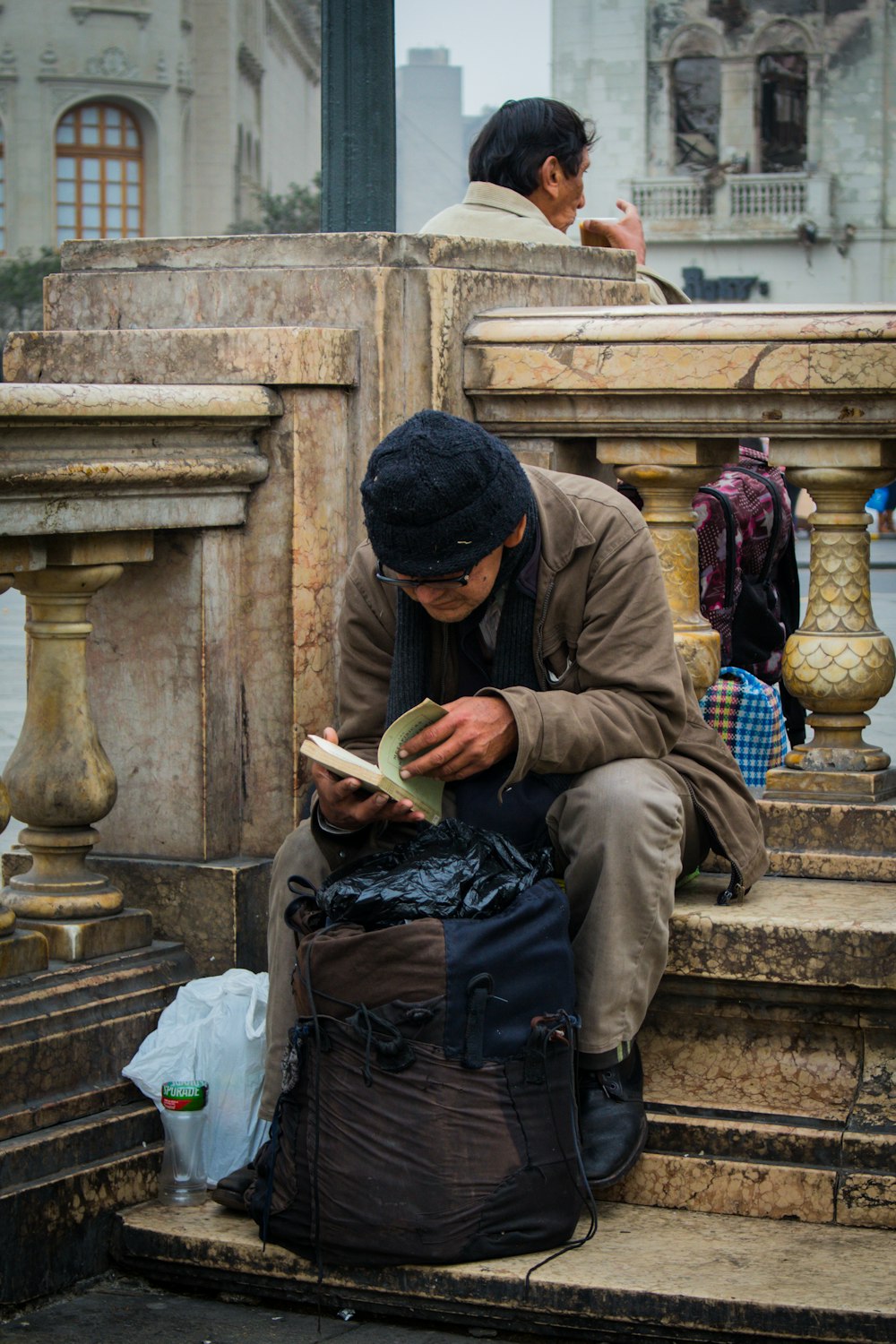 man in brown thobe sitting on stairs