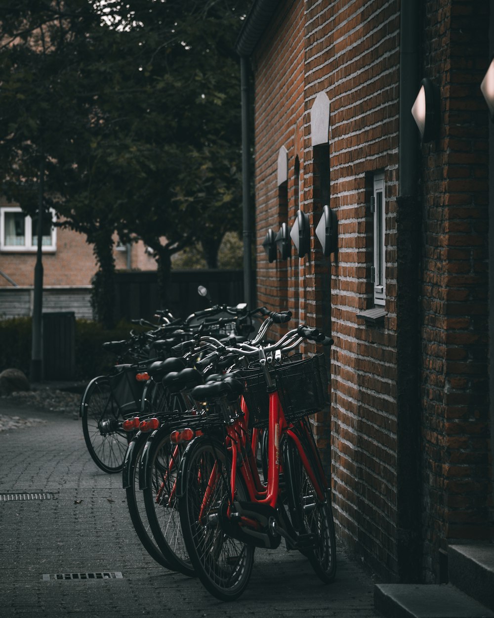 red and black bicycles parked beside brown brick wall