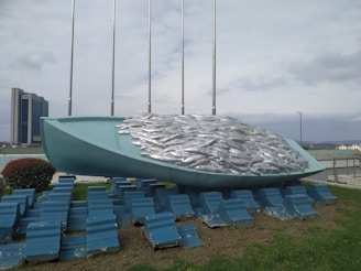 Close-up of a large, wave-inspired art installation symbolizing the tsunami's power at the 'Ola en el Puerto' exhibition.