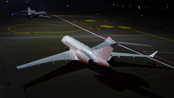 Cinematic night shot of a sleek private jet poised on a dimly lit runway under a starless sky.