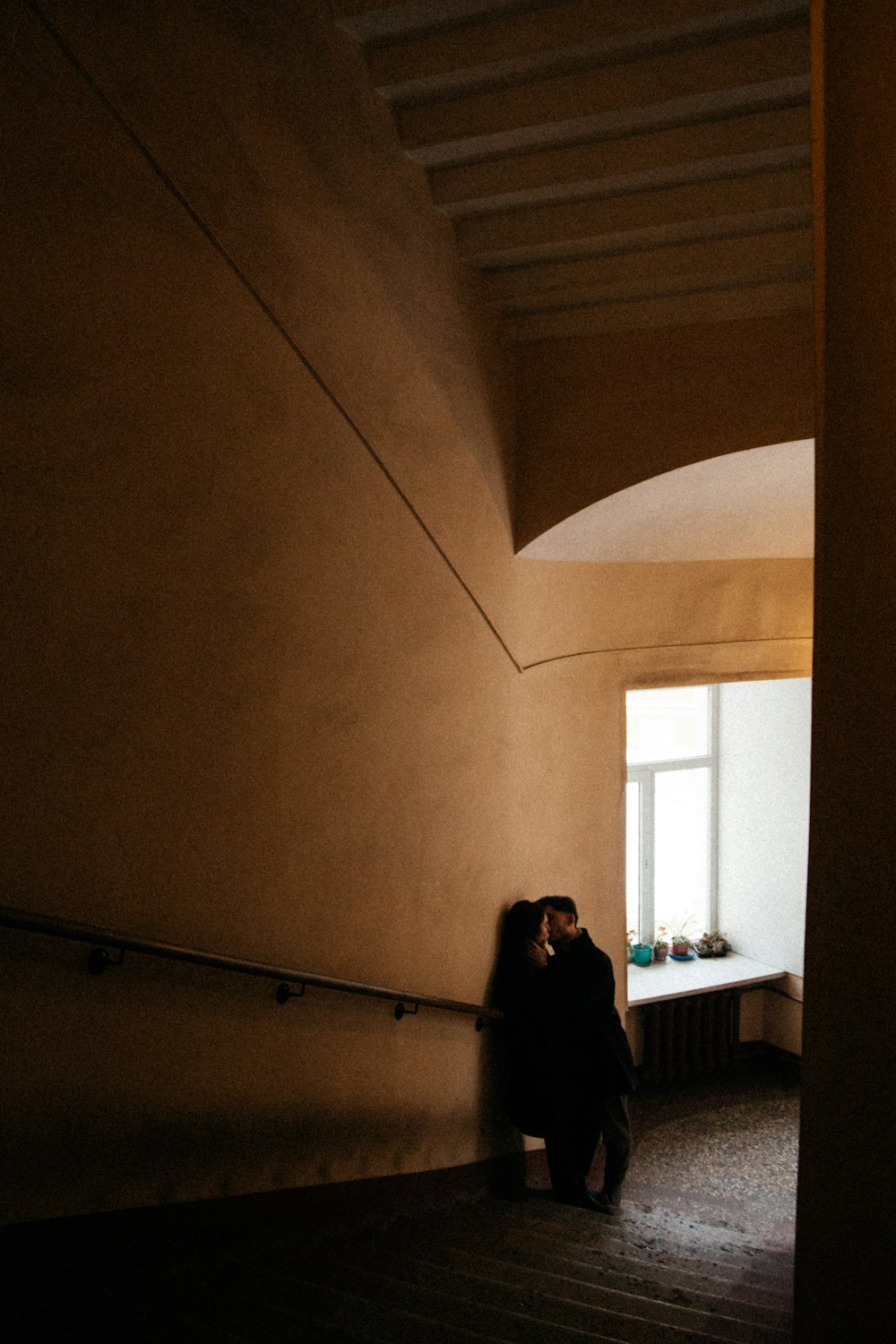 woman in black jacket standing near window