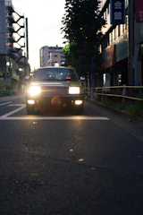 An inspector conducting a car evaluation at dusk, with city lights beginning to glow.