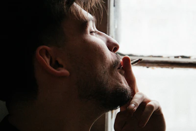 Close-up of a thoughtful person holding a cigarette, contemplating quitting.