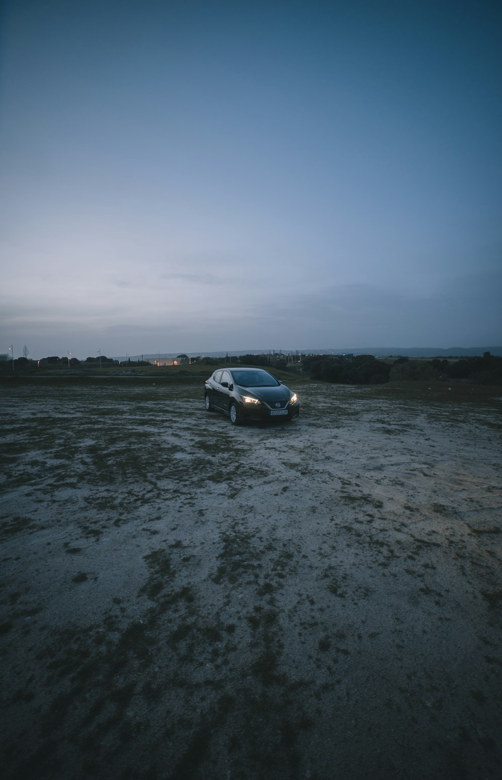 white car on gray sand near body of water during daytime