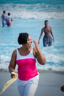 A joyful woman doing yoga on the beach wearing a soft pink and nude activewear set