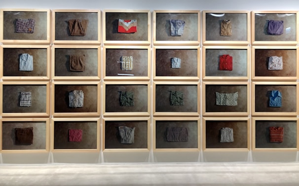 An artful wall installation combining framed prints and streetwear items, creating a dynamic visual story.