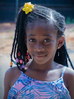 Young girl smiling with colorful beads braided into her hair.