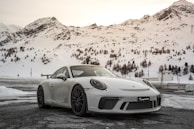 A sleek vehicle parked near a snowy mountain resort in the Pyrenees.