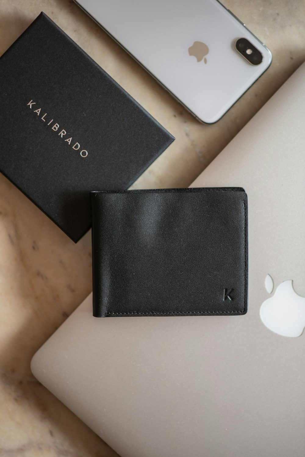 black leather bifold wallet on white table