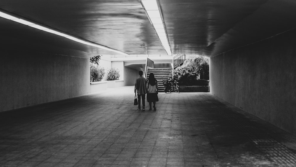 grayscale photo of people walking on hallway