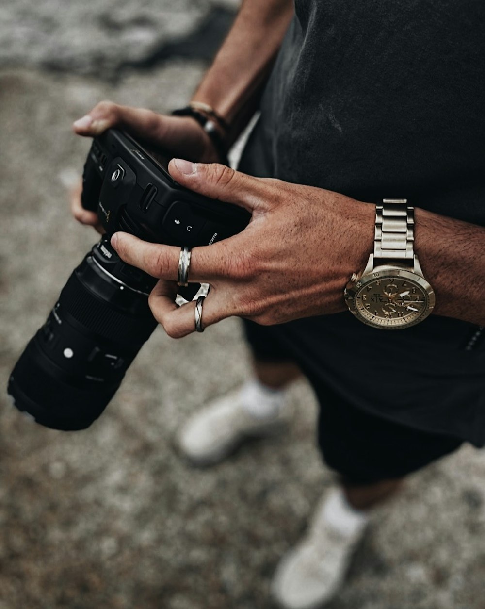 person wearing black leather strap gold round analog watch