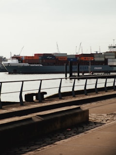 A large cargo ship loaded with containers docked at a busy port.