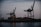 Heavy cargo being lifted by a modern overhead crane in a busy port environment at dusk.
