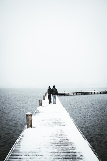 man in black jacket standing on dock during daytime