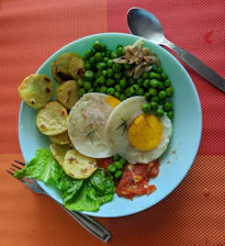 A vibrant plate showing a stuffed omelette with arrachera and chistorra, accompanied by fresh fruit and a cup of steaming coffee served in a rustic clay mug.