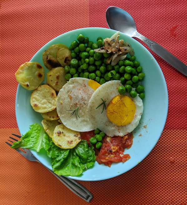 A colorful breakfast plate featuring eggs, fresh vegetables, and traditional sides served at Khobza wa Tasbeera
