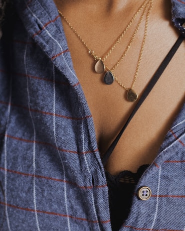 A young man showcasing his individuality with layered necklaces.
