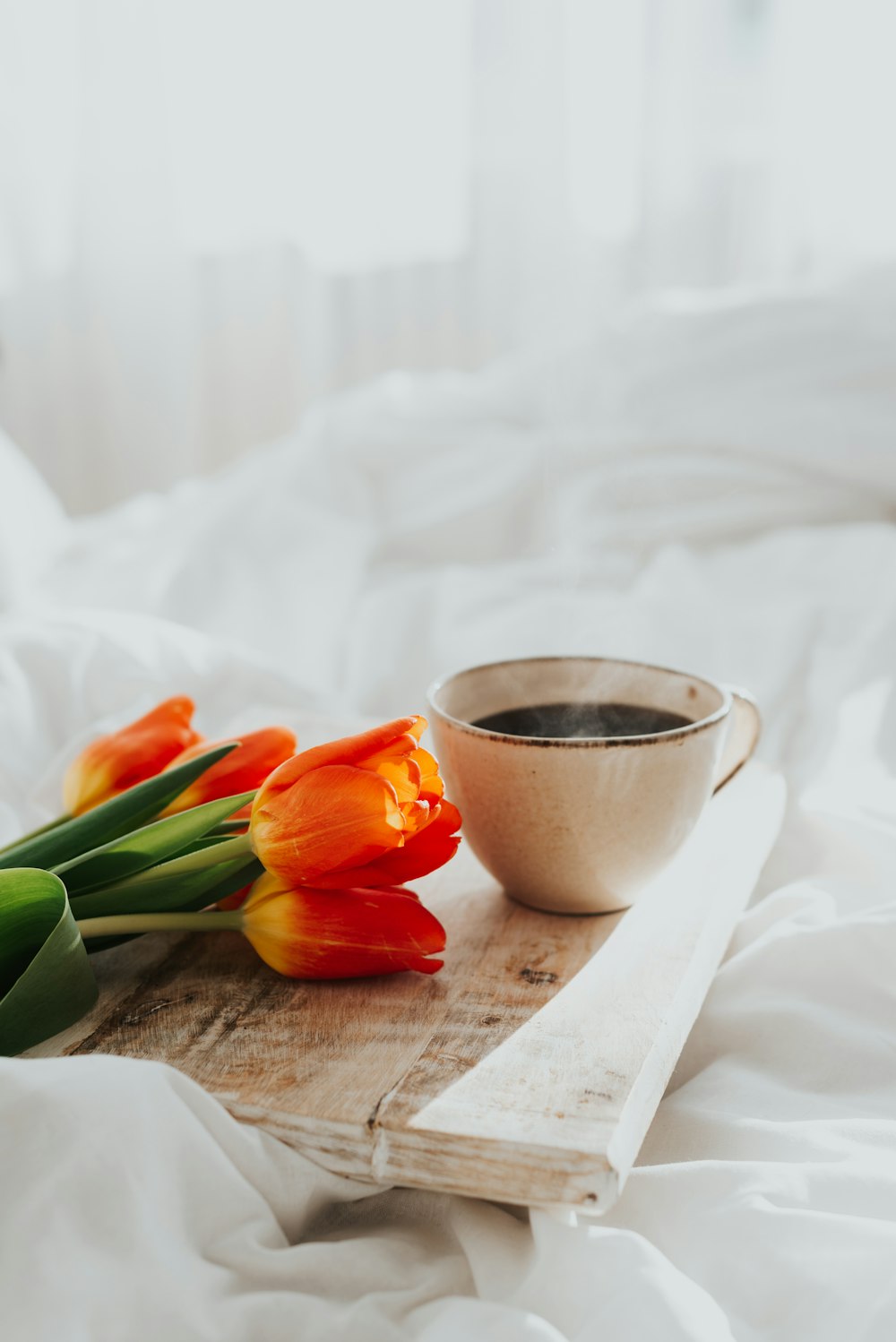 orange tulips on brown wooden table