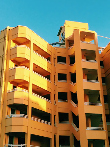 A bright, modern home exterior bathed in warm orange light reflecting Brookfield Home Builders' signature theme.