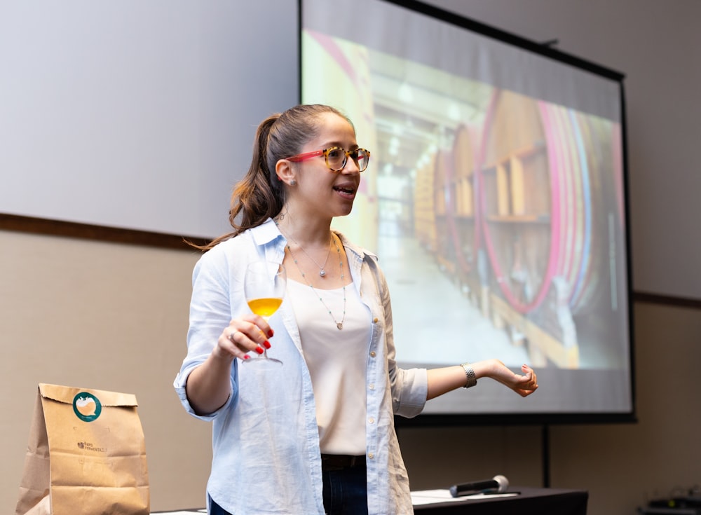 woman in white button up shirt holding yellow cup