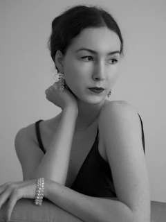 Black and white editorial-style portrait of a woman showcasing minimal, refined jewelry.