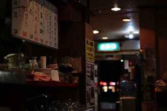 Warm interior of a small yakitori restaurant with wooden counters and soft lighting.