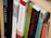 A close-up view of books arranged on a wooden shelf, with titles focusing on theological and religious themes. The spines of the books display various colors and fonts, suggesting a scholarly collection.