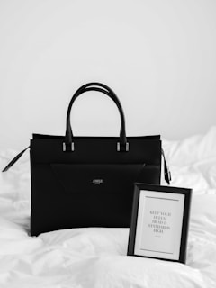 black and white paper bag on white textile