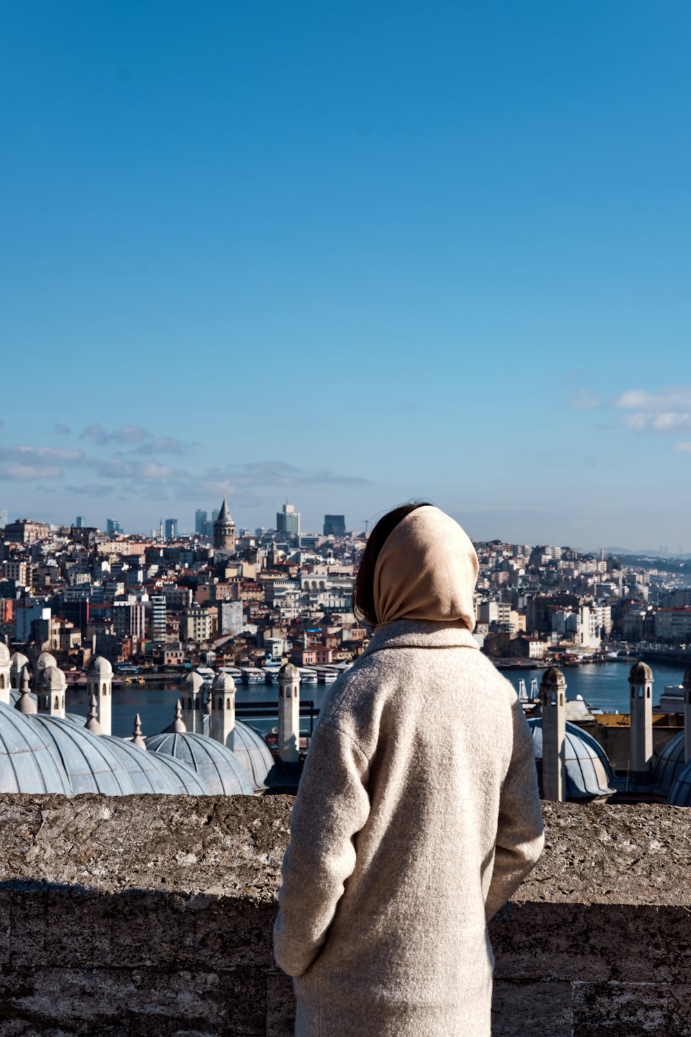 person in gray hoodie standing on top of building during daytime